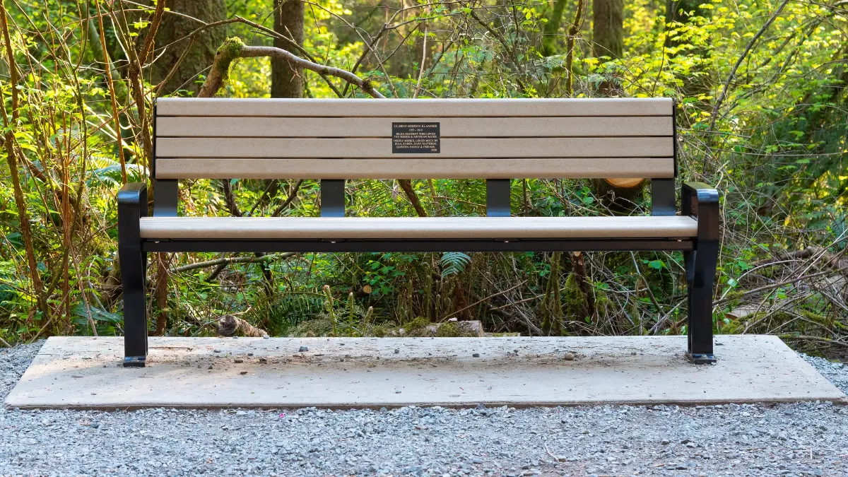 A Koble memorial bench with a bronze plaque in the backrest at Watershed Park Reserve, Delta, BC